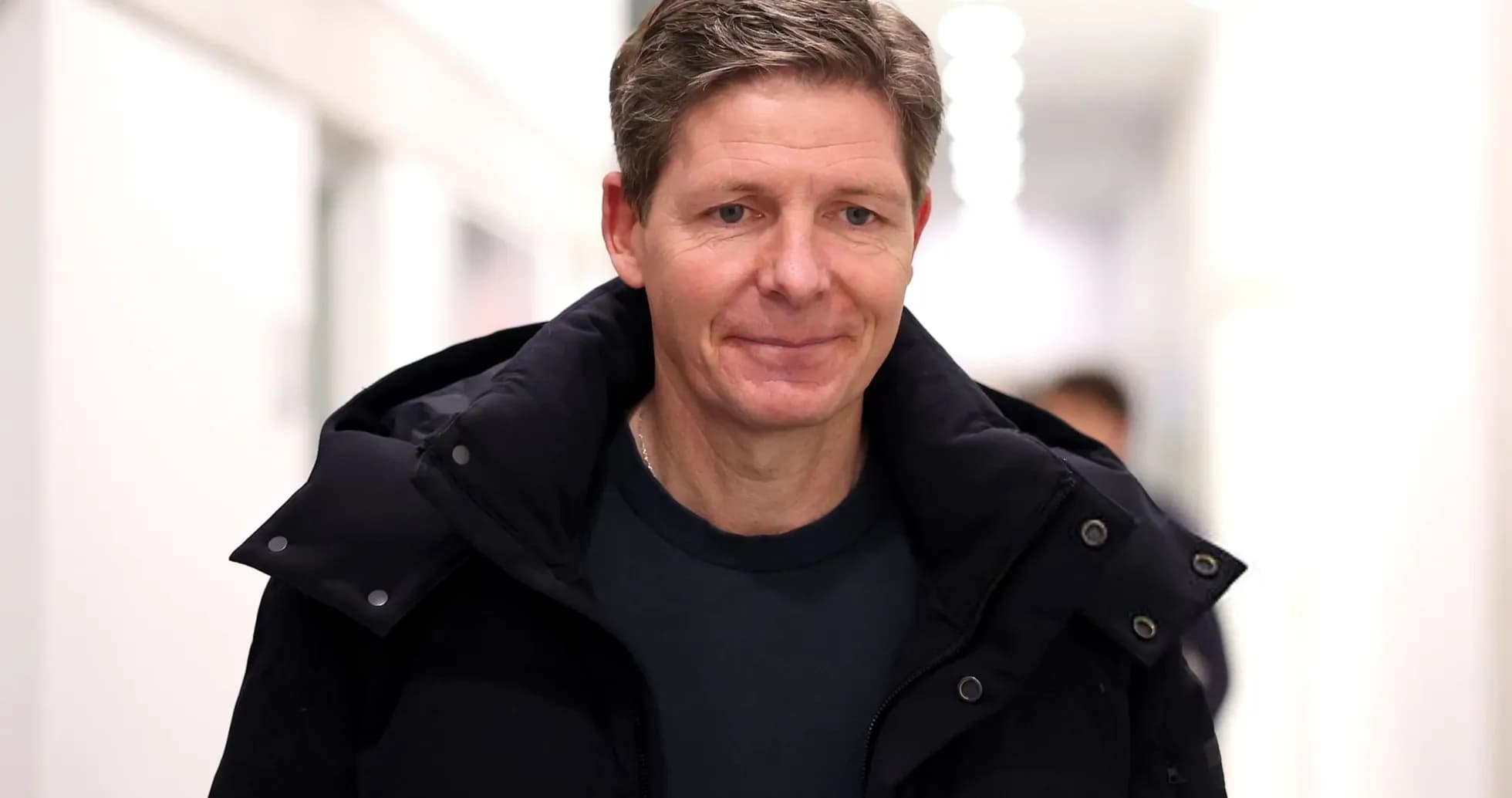 Man in black coat walking in hallway Man in black coat walking in hallway