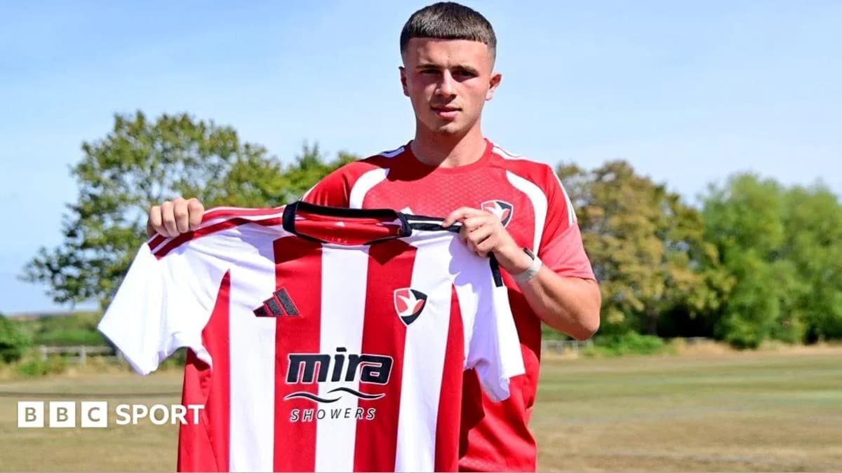 Player holding Cheltenham Town jersey at training ground Player holding Cheltenham Town jersey at training ground