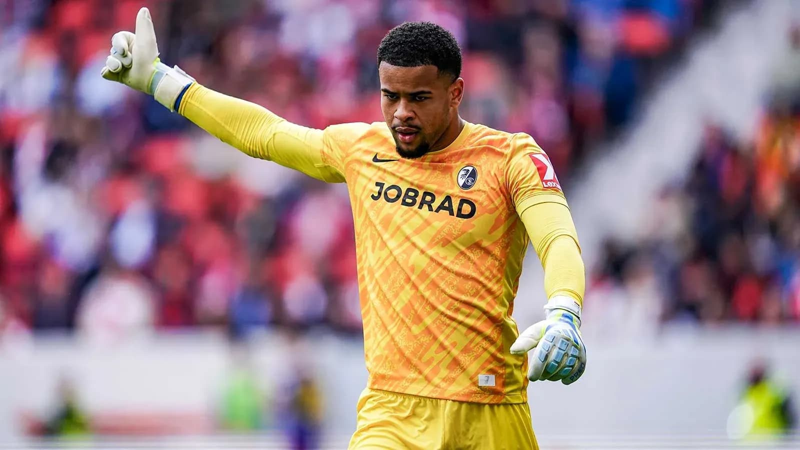 Goalkeeper gesturing during a match in yellow kit Goalkeeper gesturing during a match in yellow kit