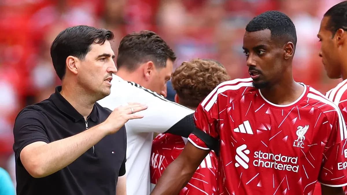 Coach discussing strategy with Liverpool player on sideline Coach discussing strategy with Liverpool player on sideline