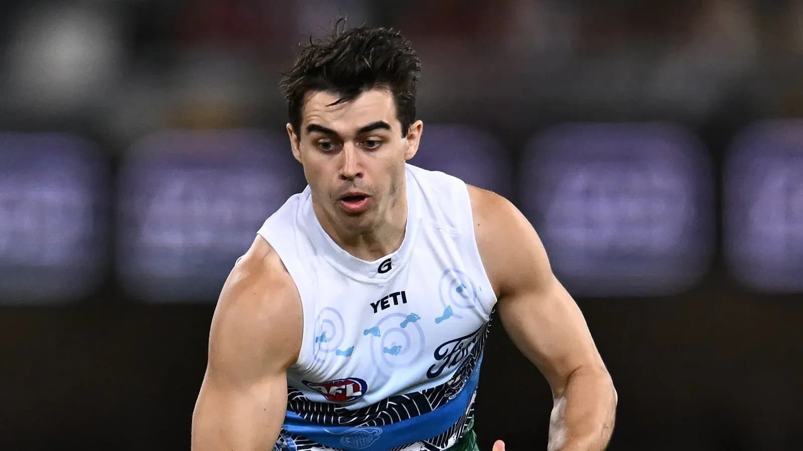 Player running with the ball during AFL match Player running with the ball during AFL match