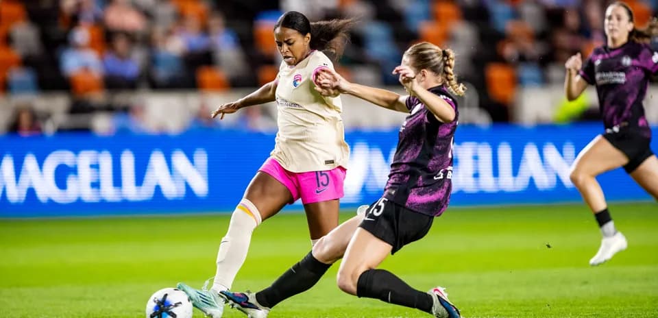 Player tackling opponent during NWSL match Player tackling opponent during NWSL match