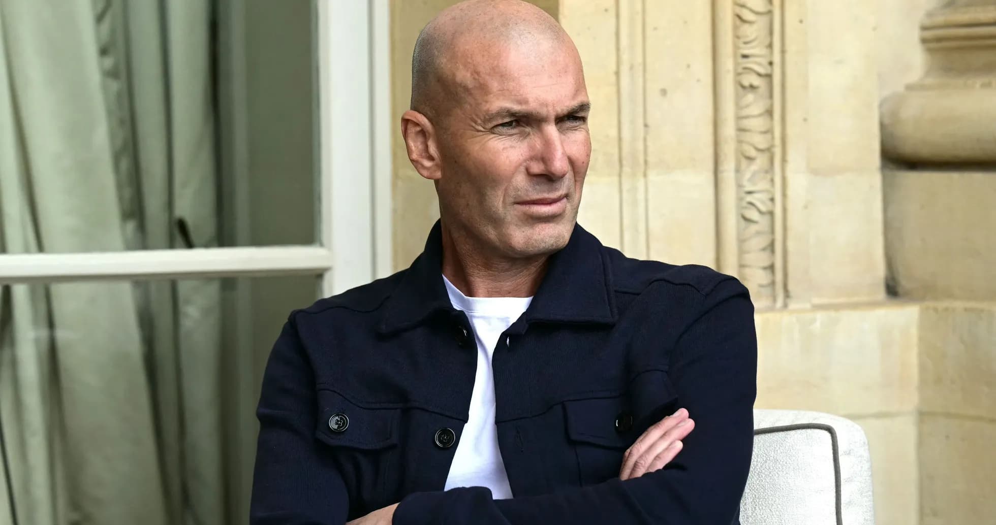 Man sitting with arms crossed, looking thoughtfully Man sitting with arms crossed, looking thoughtfully