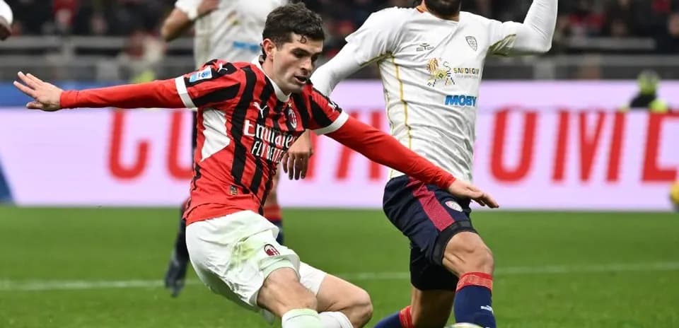 AC Milan player challenging Cagliari opponent AC Milan player challenging Cagliari opponent