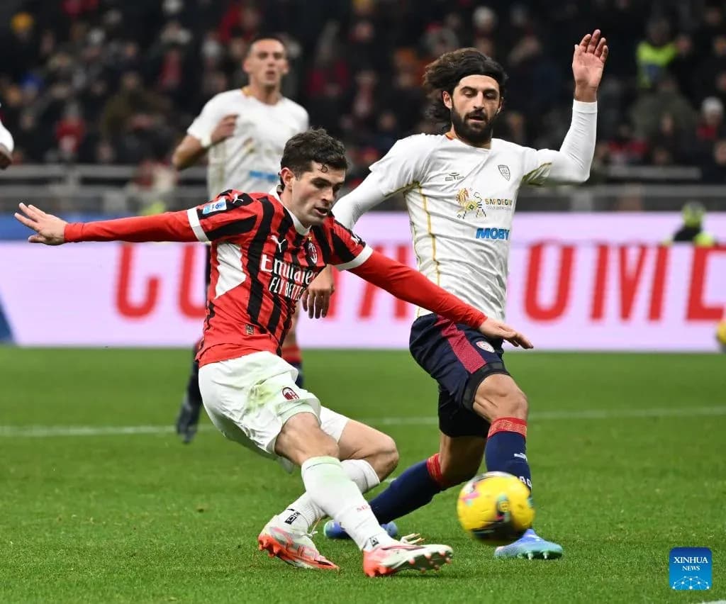 AC Milan player challenging Cagliari opponent AC Milan player challenging Cagliari opponent