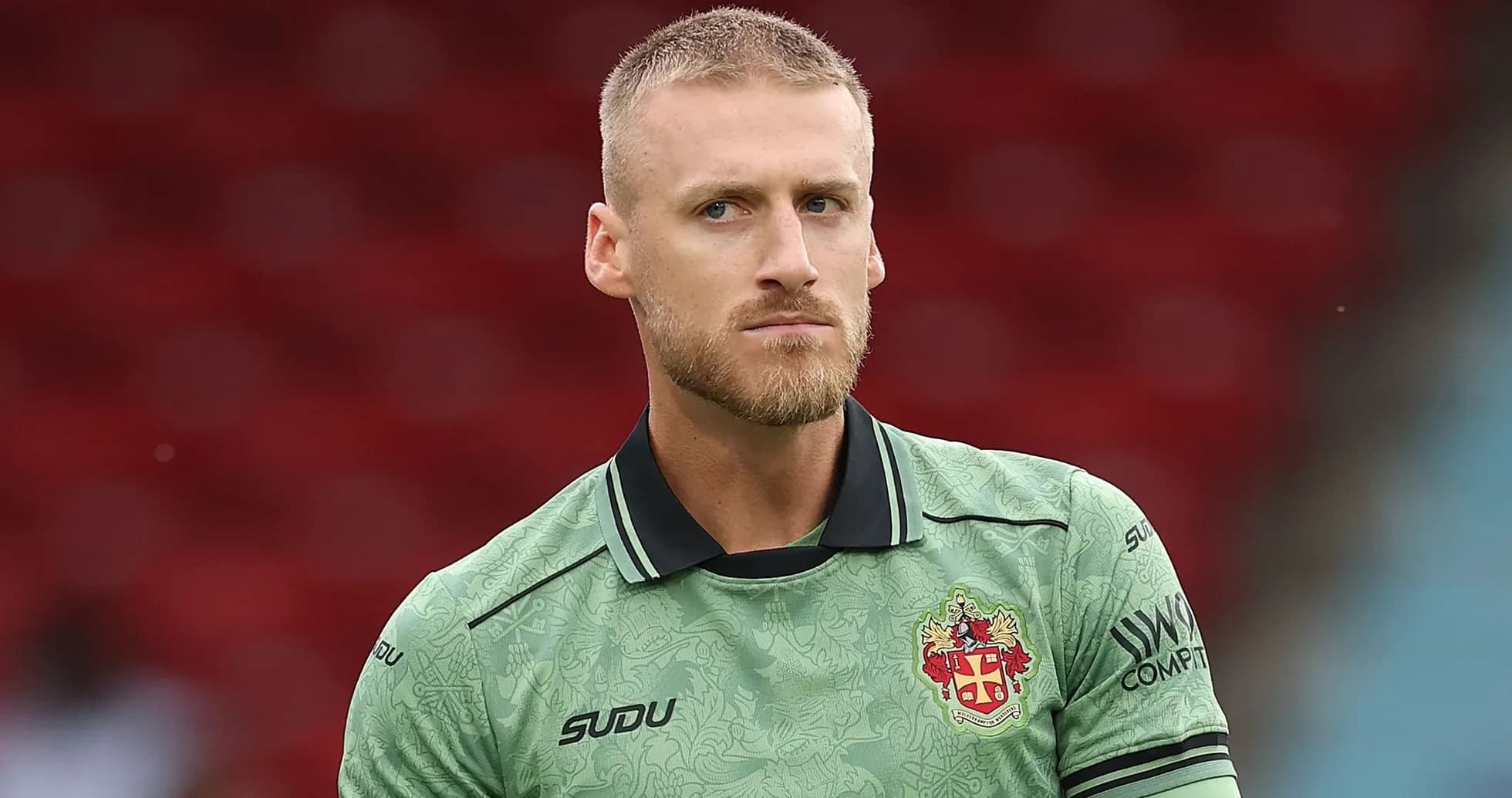 Goalkeeper wearing green kit on the pitch Goalkeeper wearing green kit on the pitch