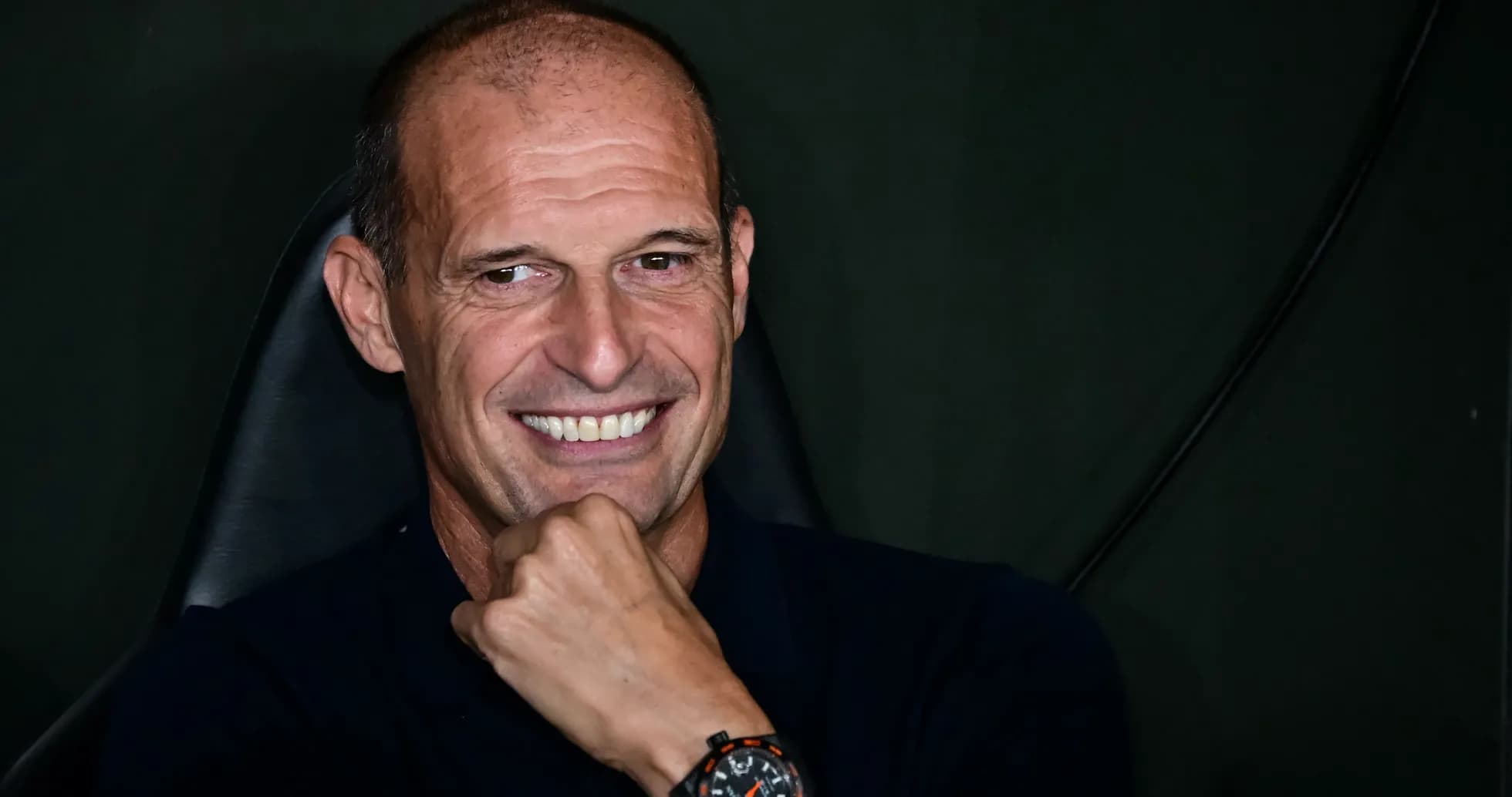 Coach smiling while seated in a chair Coach smiling while seated in a chair