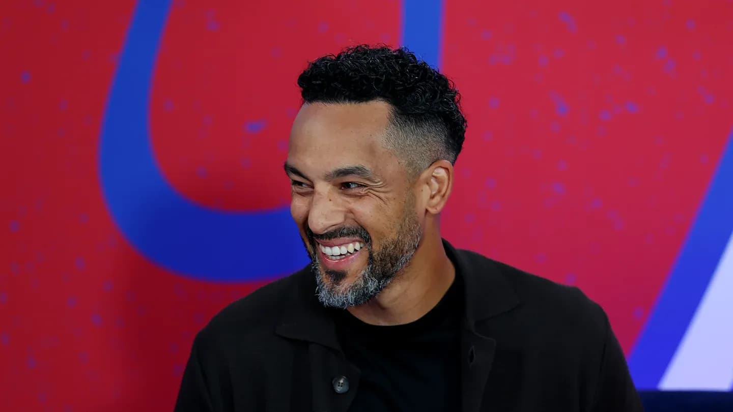 Man smiling during an interview with red background Man smiling during an interview with red background